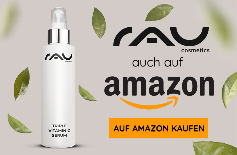 Flasche mit dreifachem Vitamin C-Serum von RAU Cosmetics mit Sprühdüse, umgeben von grünen Blättern, mit Amazon-Logo.