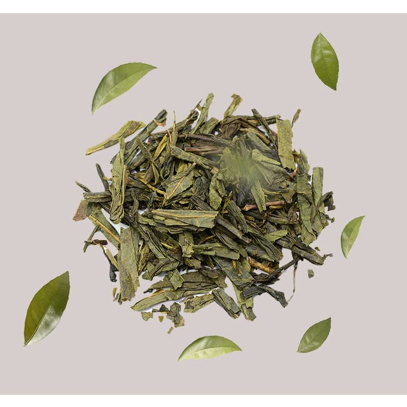 greuner-tee GrΓΌner Tee BlΓ€tter und frische TeeblΓ€tter auf grauem Hintergrund, symbolisierend die natΓΌrlichen Inhaltsstoffe des RAU Tri-Peelings fΓΌr Hautregeneration und Anti-Aging.