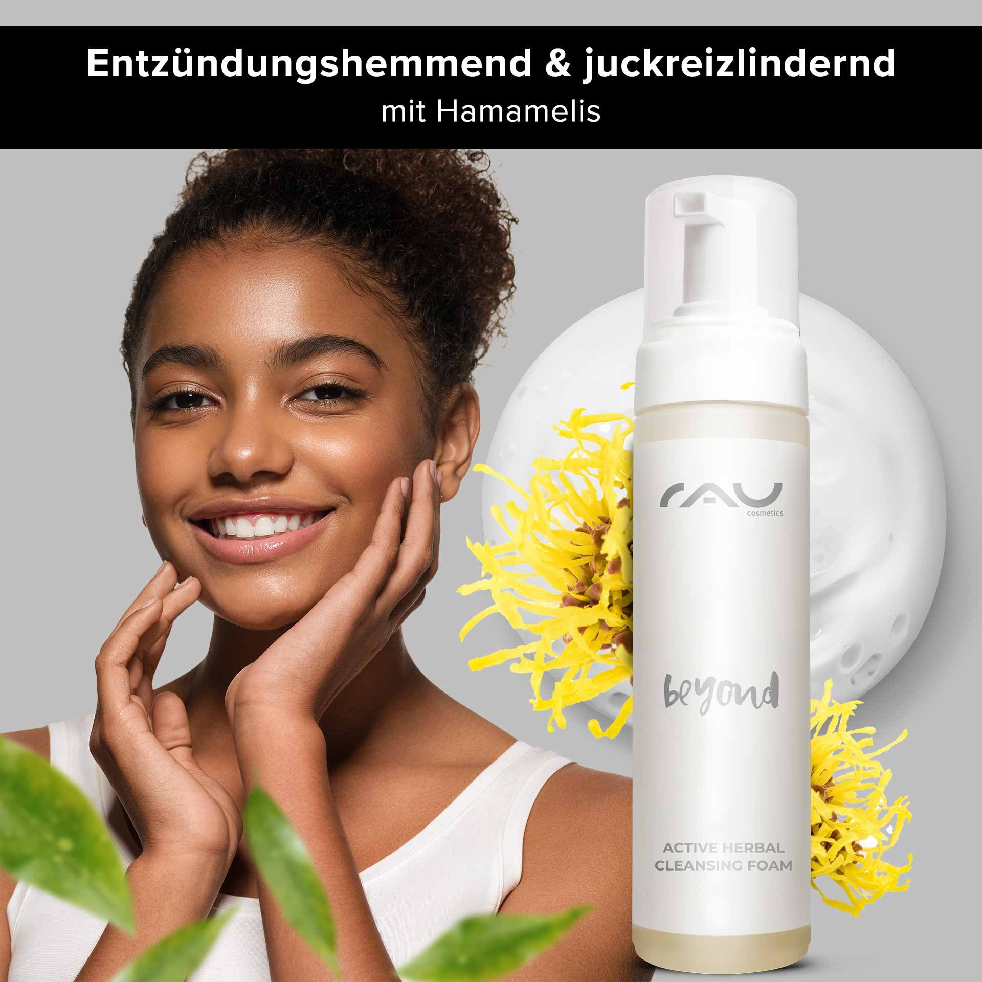 Donna sorridente dalla pelle liscia che presenta RAU Cosmetics Active Herbal Cleansing Foam, circondata da fiori di amamelide e foglie verdi, sottolinea le proprietà antinfiammatorie del detergente viso.